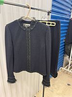 Front view of St. John knit jacket and skirt on hanger