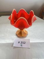 Front view of ruffled orange slag glass compote on pedestal foot