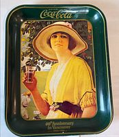 Top view of green Coca-Cola anniversary metal tray with vintage lady graphic