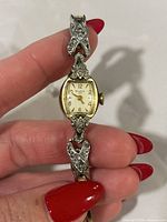 Close-up of watch dial, bracelet links with stone accents