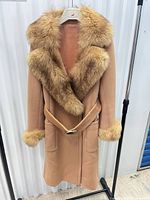 Front view of camel coat showing fox fur collar, cuffs, belt and pockets