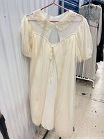 Front view showing lace collar, puff sleeves, ribbon tie