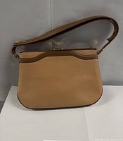 Front view of tan and brown leather shoulder bag with strap