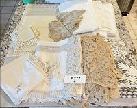 Overall lot showing folded tablecloths, napkins and doilies