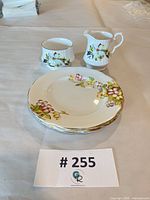 Full lot overview showing three plates stacked plus creamer and sugar bowl