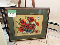 Full view of framed needlepoint tapestry leaning on wall
