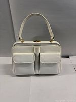 Front view showing two flap pockets, handle and clasp