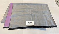 Full view of scarf showing grey side with lavender reverse edge and black fringe