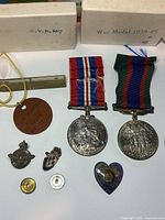All items grouped showing medals, pins, dog tag, whistle, boxes and buttons