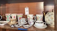 Overall view showing teapot, tall cups, small cups, trays and accessories