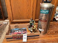 Overall lot showing both figurines, book and stainless soda-acid extinguisher