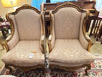 Front view of both bergère armchairs showing frames and upholstery