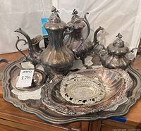 Group view of coffee pot, teapot, sugar bowl, creamer, large tray, shell dish, pierced plate