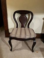 front view of the oak chair showing balloon back design and striped cushion