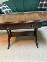 Full view of coffee table showing drawer, lower shelf, legs