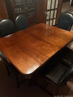Rectangular oak dining table surface with four of six chairs shown