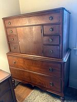 Front view of tall oak dresser showing drawers, center cabinet and overall design