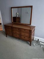 Front view of solid oak dresser with mirror showing all drawers and framed mirror