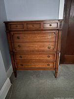 Front view of walnut dresser showing drawer configuration and hardware