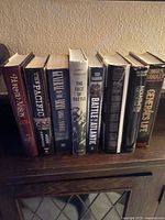 Front view of nine hardcover military history books on cabinet top