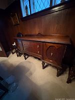 Front view of solid oak buffet showing drawers, cabinets, turned legs