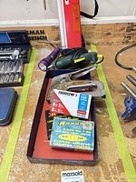 Arrow stapler with staples boxes and glue gun displayed in tray