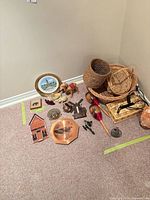 Full lot overview showing baskets, plates, figurines, maracas, copper plate and salt lamp