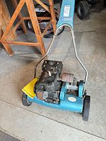 Full mower view showing engine, deck, handle and front wheel