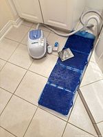 Full system laid out: pump unit, remote, manual, mat sections connected, hose attached.