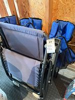 Folded zero-gravity lounge chair and three folded camping chairs