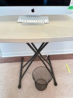 Full view of table surface, legs and wastebasket