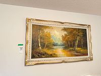 Front view of framed autumn landscape painting on wall