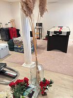 entire lot showing glass bottle with reeds and surrounding artificial flowers and succulent