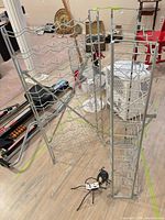 Two chrome wire wine racks standing on floor showing full structure