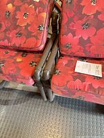 Two PVC patio chairs with floral cushions side by side