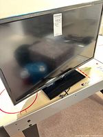 Front view of RCA 32" LED TV on stand