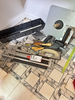 Group view of tile cutter, mixing tray, trowels, floats, level