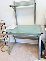 Full view of glass computer desk with upper shelf