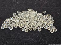 Pile of clear round faceted stones on black background