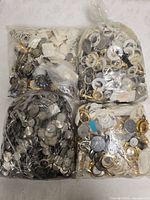 Four ziplock bags filled with assorted wristwatch parts