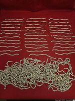 Overview of all strands and loose beads on red background