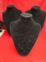 Front view of three black velvet necklace display stands