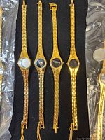 Close-up of four loose watch cases highlighting gold-tone finish and empty dials