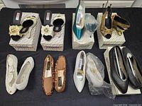 All nine pairs of women’s shoes displayed on table, four pairs on Caramella boxes, five pairs in front