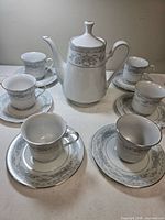 Full view of pot with six cup and saucer sets