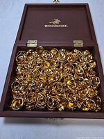Winchester wooden box full of gold-tone rings