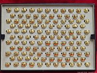 Full tray showing rows of gold-plated Om signet rings