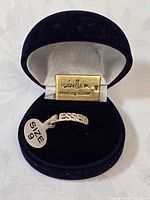 Ring in open box showing brand plaque and size tag