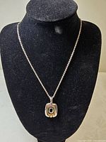 Full necklace on display bust showing chain and pendant