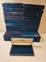 Stack of 25 navy blue velvet jewelry boxes, one opened to show interior